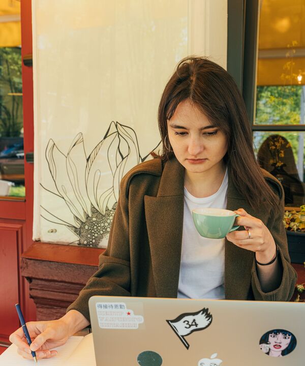 A member taking a survey on her laptop over coffee