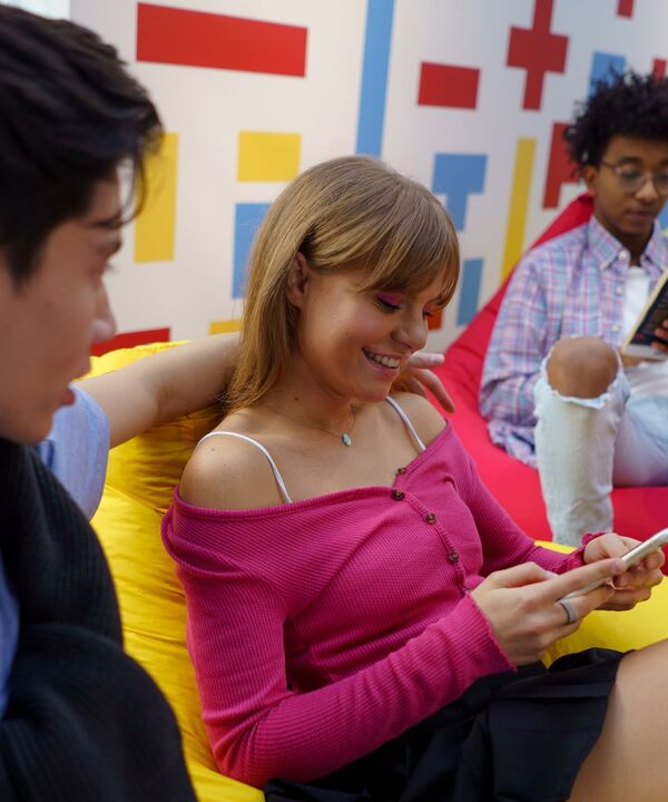 Friends relaxing together while one checks her phone
