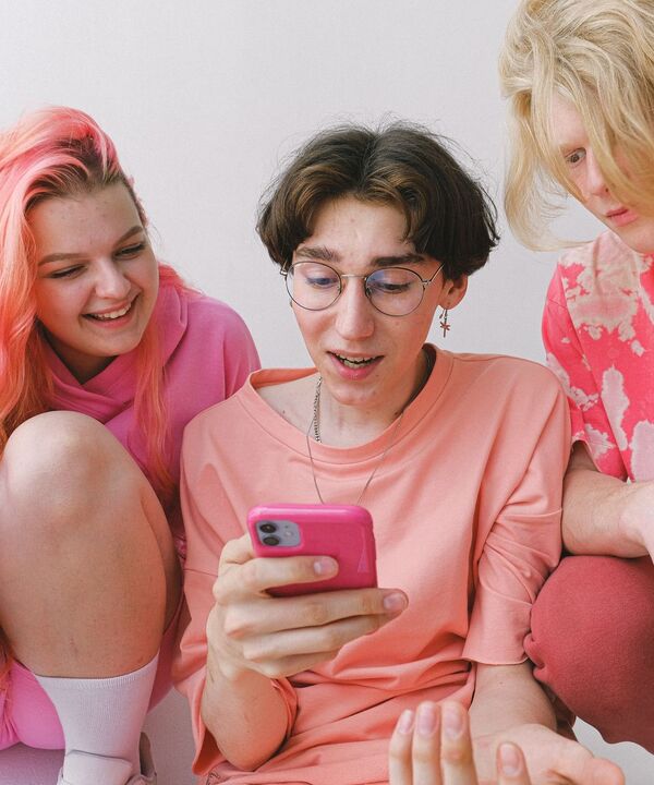 Friends looking at rewards on a phone together