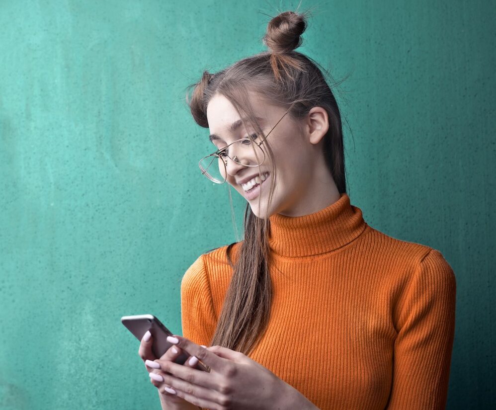 A member laughing as she answers a survey on her phone